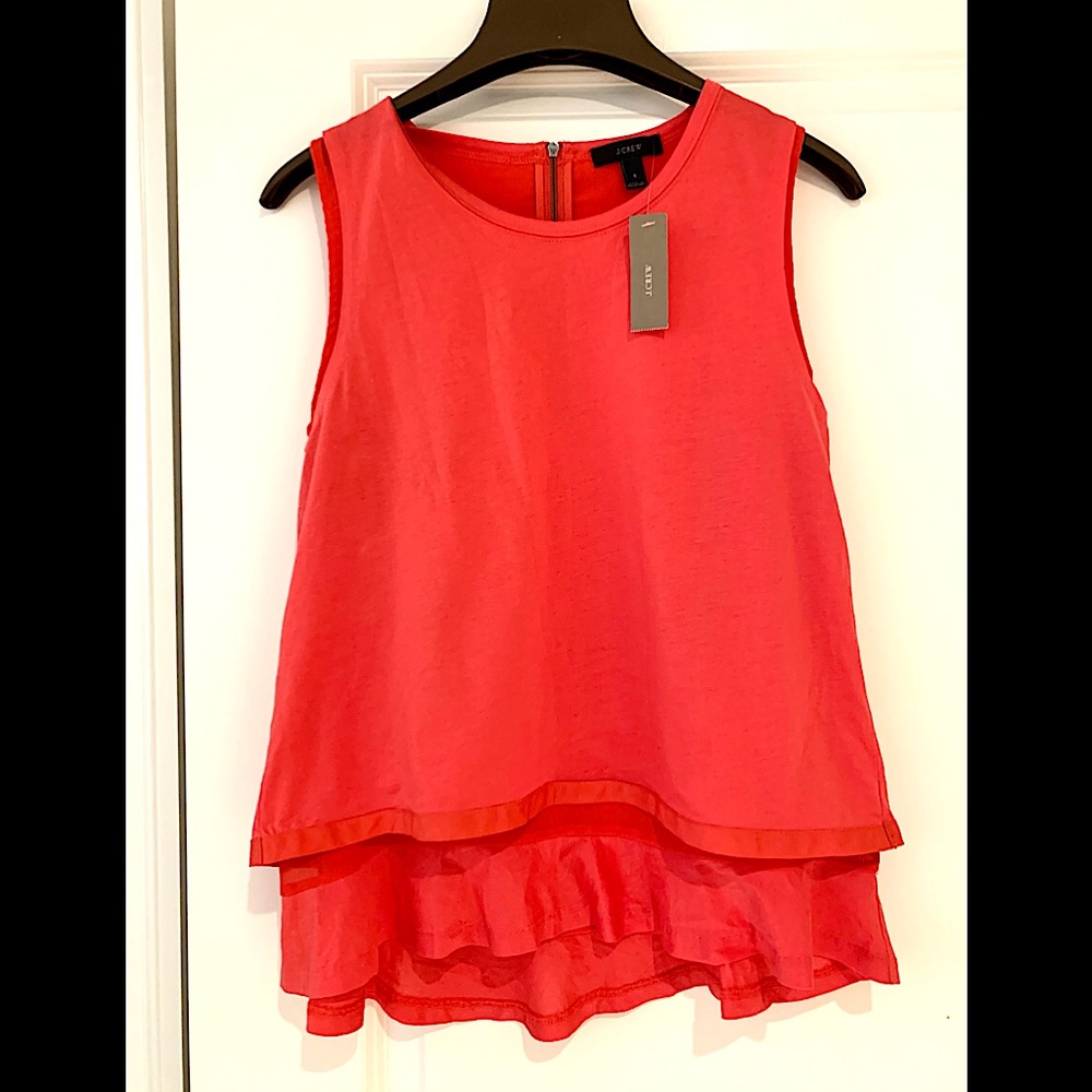 Sleeveless blouse with ruffles on the trim.